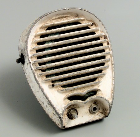 SA white painted speaker showing clear signs of rust and ageing. The paint is wearing away around the speaker’s edge revealing the metal underneath. 